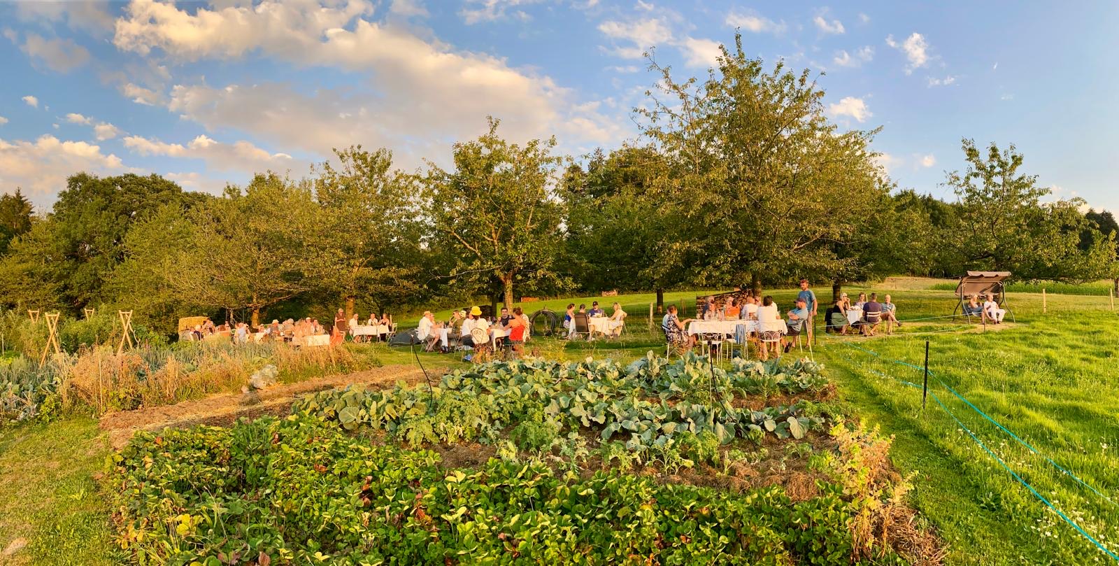 Les convives attablés au milieu du potager, au coucher du soleil
